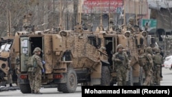 Ushtarët e NATO-s inspektojnë pranë një lokacioni në Kabul më 25 mars 2020. 