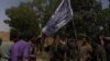 The Afghan forces hold a Taliban flag after overrunning an insurgent hideout in Marjah on July 22. 