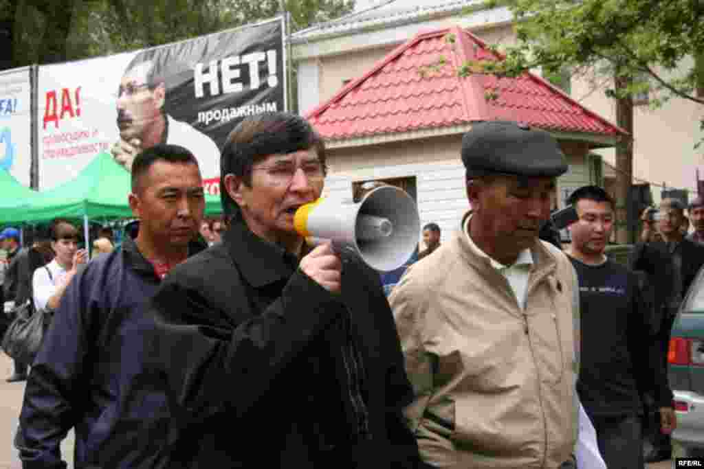 Политик Жасарал Куанышалин требует у полицейских пропустить шествие оппозиции. Алматы, 1 мая 2010 года. 