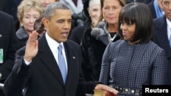 U.S. President Barack Obama (left) recites his oath of office as First Lady Michelle Obama looks on during the swearing-in ceremonies at the U.S Capitol in Washington, D.C., on January 21.