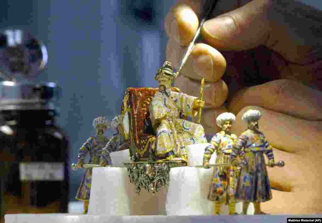 A restorer carefully enamels a figure from the Grand Mogul's birthday. This photo was taken in 2004.
