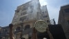 Protesters hold up an emblem of the Muslim Brotherhood removed from the party&#39;s headquarters, which was looted and set on fire by angry crowds.