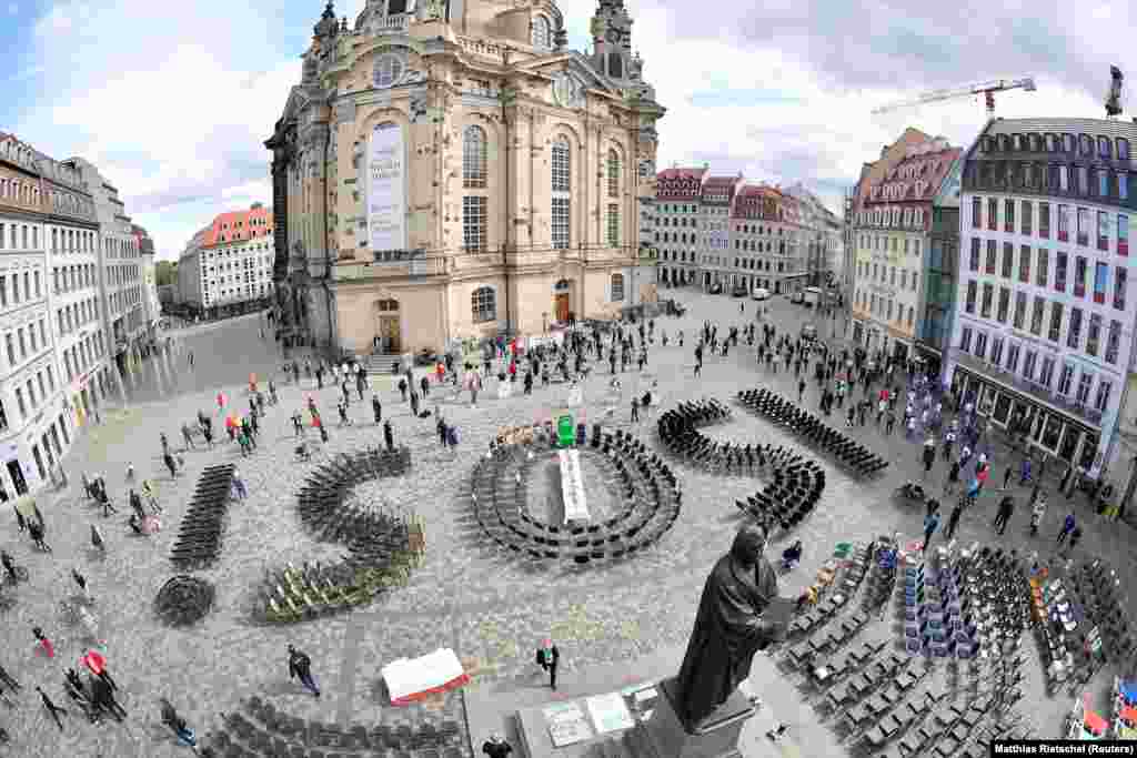 Empty chairs arranged to display &quot;SOS&quot; are placed in Neumarkt Square in Dresden to call attention to the difficult situation of hotel and restaurant owners in Germany due to the coronavirus. (Reuters/Matthias Rietschel)