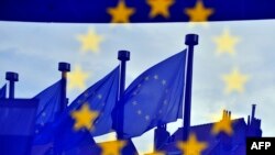 Drapele ale Uniunii Europene reflectate la intrarea în clădirea Berlaymont a Comisiei Europene de la Bruxelles (arhivă)