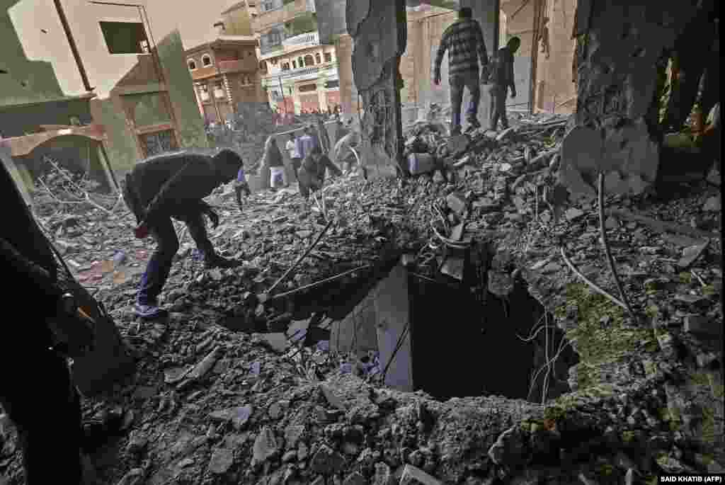 5 майда Газзә сызыгындагы Рафаһ шәһәренә Израил һава һөҗүмнәре нәтиҗәсендә җимерелгән биналарда фәлестиннәр ни дәрәҗәдә зыян килгәнен карый. (AFP/Said Khatib)