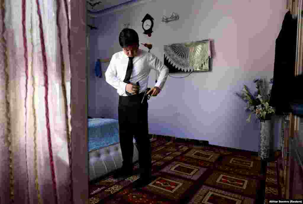 Sardar Sahil, 30-year-old Hazara lawyer and rights activist, sports his licensed gun as he gets ready to leave for office, at his home in Hazara Town, Quetta, Pakistan, June 14, 2019.&nbsp;​&quot;We are living under siege for more than 1-1/2 decades due to sectarian attacks,&quot; said Sahil. &quot;Though all these checkposts were established for our security, we feel we were ourselves also cut off from other communities.&quot; Sahil carries a pistol whenever he leaves home, and relies on his faith as a second layer of security. &quot;I kiss my mother&#39;s hand and she kisses me too and says goodbye with her prayers and good wishes,&quot; Sahil said.