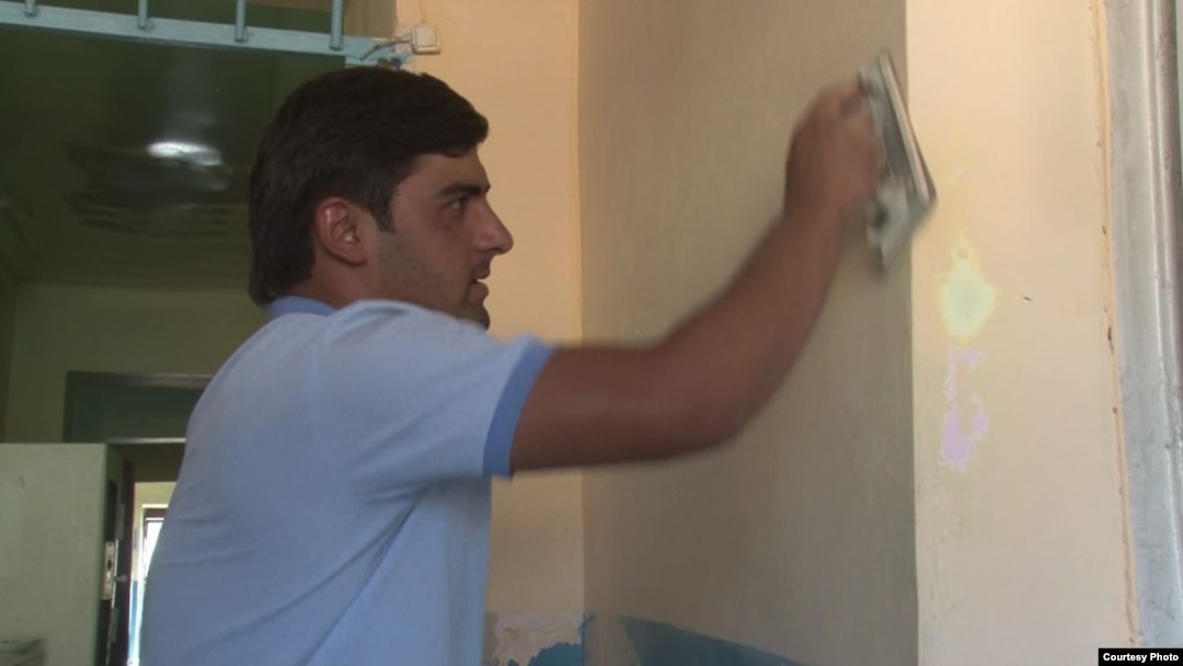 Muhammadjon Qurbonov, a Dushanbe street merchant, performing menial labor as a penalty for making lewd comments to Anisa Ibrohimova.