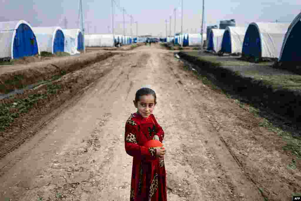 A displaced Iraqi girl who fled violence in the Islamic State (IS) stronghold of Mosul holds a balloon at the Khazer refugee camp near Irbil. (AFP/Dimitar Dilkoff)