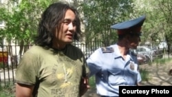 Police arrest activist Aidos Sadyqov in July.