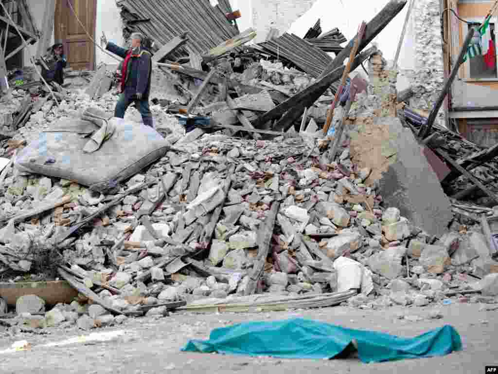 Italy - The body of a victim lies on the street in front of his collapsed house in the center of the Abruzzo capital L'Aquila, 06Apr2006 - Par2494641 Object name ITALY - EARTHQUAKE ITALY, L'Aquila : The body of a victim lies on the street on April 6, 2009 in front of his collapsed house in the center of the Abruzzo capital L'Aquila, the epicenter of an earthquake measuring 5.8-magnitude on the open-ended Richter scale. At least 20 people were killed in an earthquake that struck central Italy as most people lay sleeping early on April 6, and the death toll was rising steadily after many homes collapsed in the Abruzzo region. AFP PHOTO / VINCENZO PINTO 