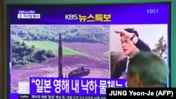 Мужчина у телеэкрана с новостным сюжетом о запуске Северной Кореей ракеты. 