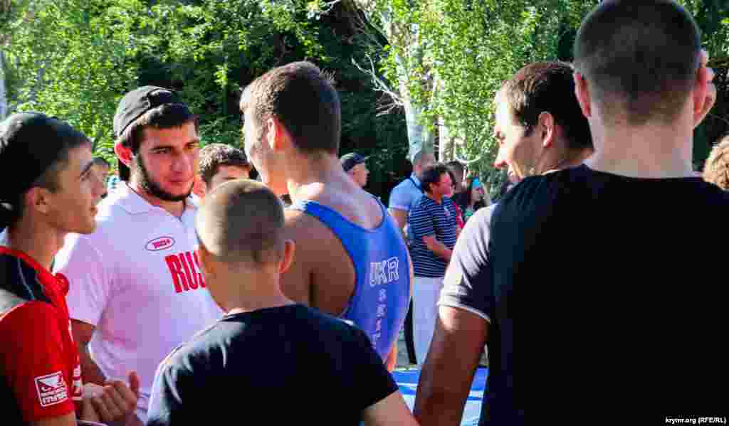 Один из борцов пришел на соревнования в украинском трико. Многие спортсмены носят футболки с надписью &laquo;Россия&raquo;.