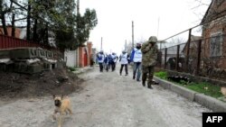 Monitors of the OSCE Special Monitoring Mission to Ukraine on a road in the village of Shyrokyne, on the outskirts of the strategic port city of Mariupol, on April 14.