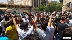 Iranians protest at Tehran's Grand Bazaar on the morning of June 25 after the black-market exchange rate for the rial currency fell by more than 10 percent in a single day. 