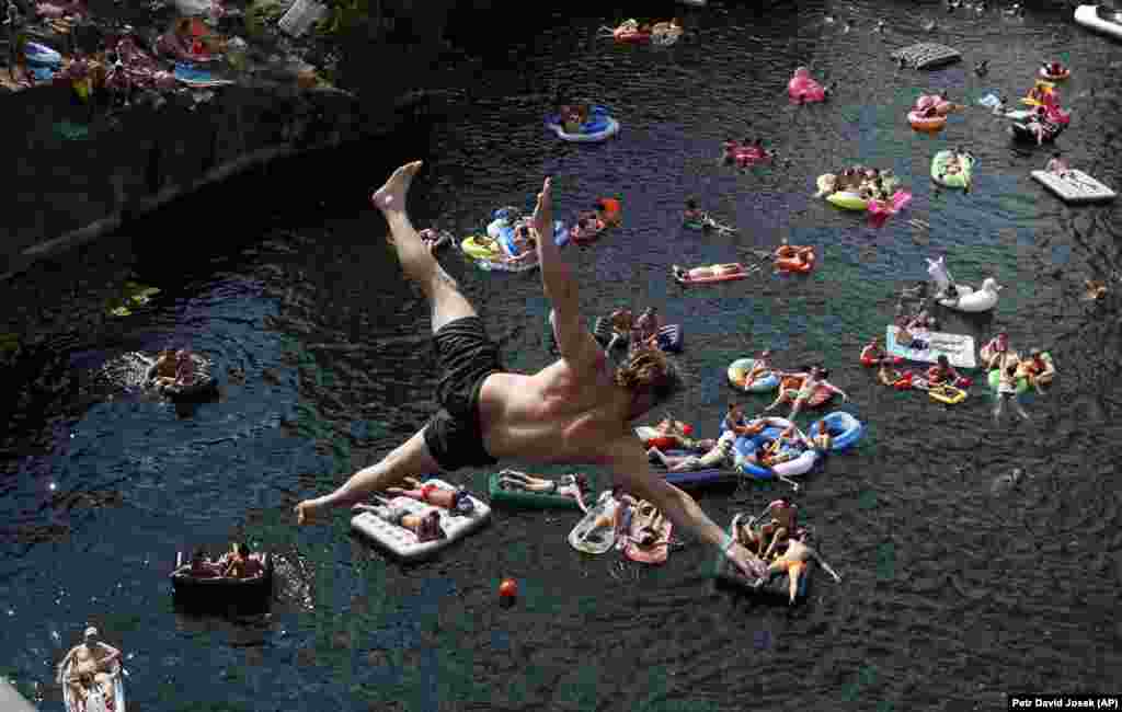 Spectators on inflatable mattresses watch as a competitor jumps into the water during a cliff-diving competition at a flooded quarry near the village of Hrimezdice in the Czech Republic on August 3. (AP/David Josek)