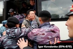 Полиция кезектен тыс президент сайлауына қарсылық білдіріп көшеге шыққан адамдарды арнаулы көлікке күштеп салып жатыр. Алматы, 9 маусым 2019 жыл.