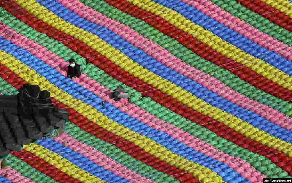 Workers adjust lanterns for the upcoming celebration of Buddha's birthday on May 22 at Jogye temple in Seoul, South Korea. (AP/Ahn Young-joon)