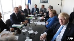 French President Emmanuel Macron (left) meets with German Chancellor Angela Merkel (center) and British Prime Minister Boris Johnson (right) at the UN on September 23.