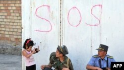 Kyrgyz police officers speak to a child in the southern city of Osh.