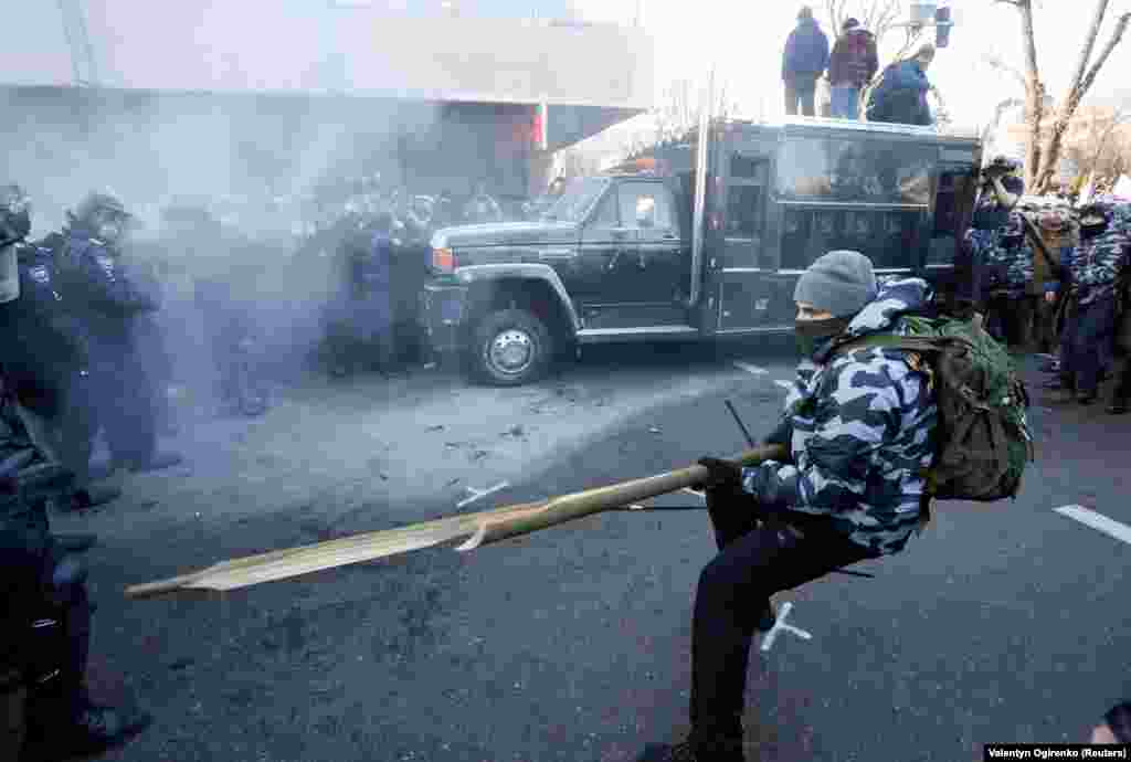 Ukrainian far-right activists attack police officers during a protest against land reform in Kyiv on December 17. (Reuters/Valentyn Ogirenko)