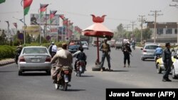 Afghan police guard at a checkpoint in Kandahar Province, site of a deadly attack on October 18.