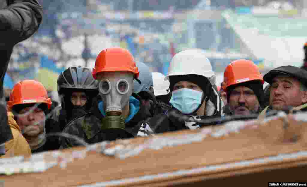 Pro-European protestors stand on a barricade that was erected to block the way to the Independence Square in Kyiv. (epa/Zurab Kurtsikidze)