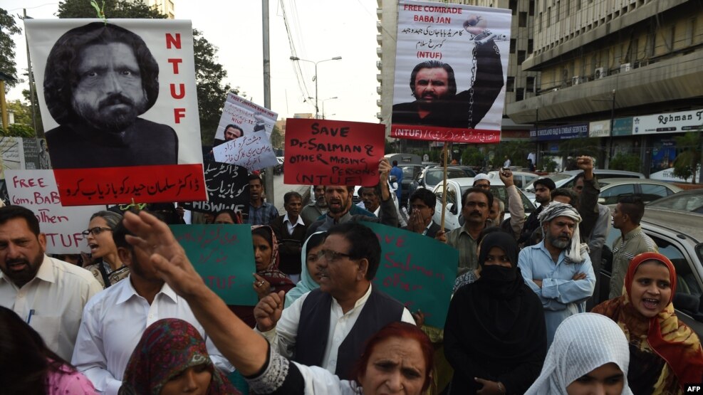 Pakistani human rights activists hold images of missing activist Salman Haider during a protest in Karachi.