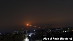 Missile fire is seen over the rebel-held city of Daraa in southwest Syria.