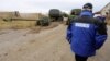 OSCE observers check a column of 15 MT-12 Rapira 100-mm antitank guns being withdrawn by Russian-backed separatists from Donetsk to the village of Zelene on October 28.
