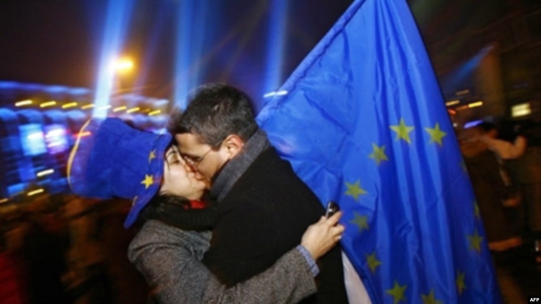 România - Un cuplu de români se sărută după miezul nopții în timp ce țin steagul UE la o petrecere de Anul Nou în Piața Universității din București - 01 ianuarie 2007, ziua în care România a devenit stat membru al Uniunii Europene. 