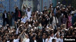 FILE: Afghans revers us use their mobile phones to capture the celebration of the Afghan New Year Norouz in Kabul.