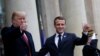 U.S. President Donald Trump and French President Emmanuel Macron gesture as they meet at Elysee presidential palace.