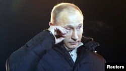 Vladimir Putin îşi şterge lacrimile de bucurie, în faţa suporterilor săi adunaţi pe Manejnaia, în apropierea Kremlinului.