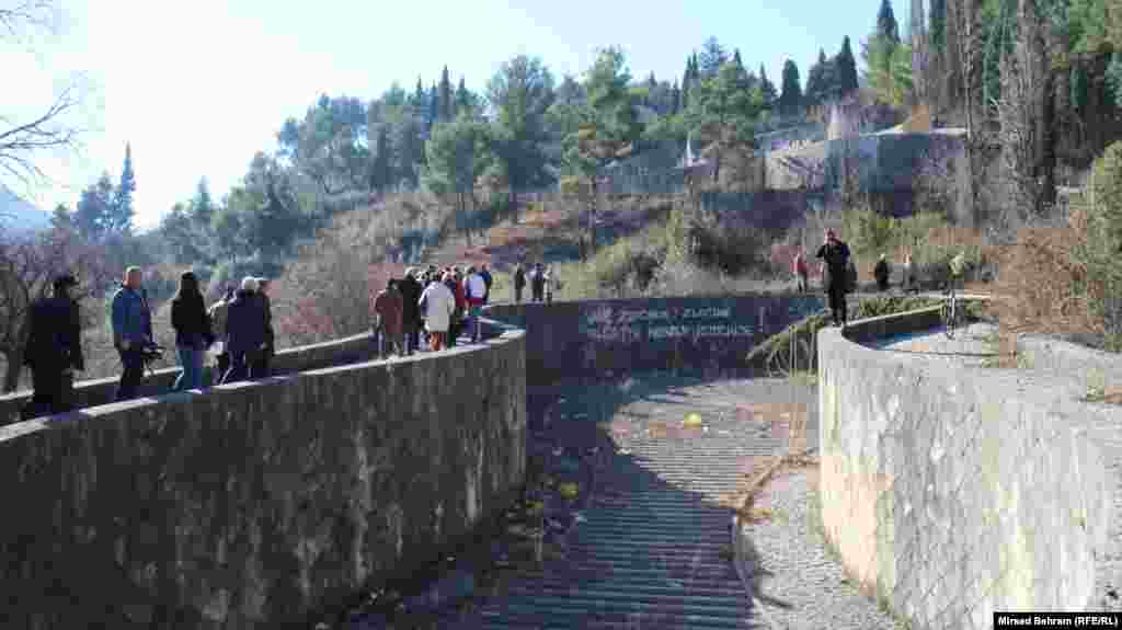 Posjetioci prolaze na Partizanskom groblju pored grafita koji je ujutro 14. februara &quot;osvanuo&quot; na jednom od zidova unutar kompleksa