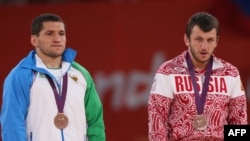 Uzbekistan's Soslan Tigiev (left) with Russia's Denis Tsargush on the podium at the London 2012 Olympic Games in August.