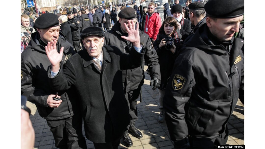 An elderly man is detained by police in Minsk.