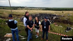 Сотрудники миссии ОБСЕ на месте падения обломков Boeing 777 в Донецкой области. 18 июля 2014 года.