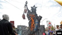 FILE - Pro-government demonstrators burn anti US and Israeli effigies during a rally marking Al-Qods Day (Jerusalem Day), in support of Palestinian resistance against Israeli occupation, in Tehran, July 1, 2016. 