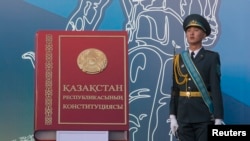 Қазақстан конституциясы макетінің жанында тұрған әскери қызметкер. Алматы, 30 тамыз 2014 жыл.