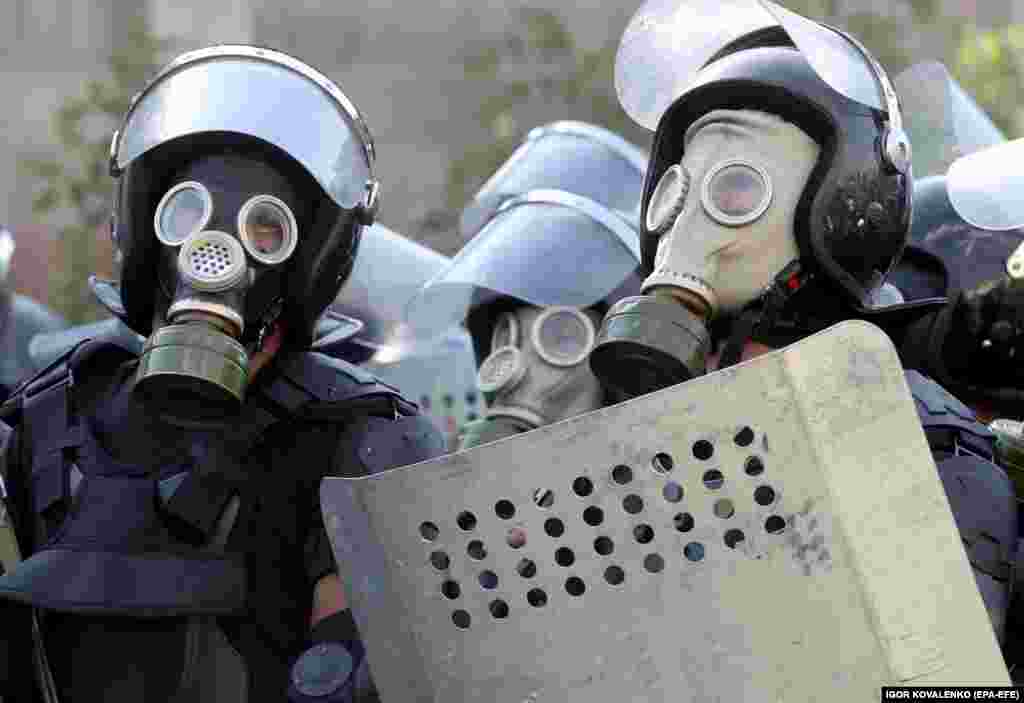 Police in gas masks during the August 8 operation. After an initial attempt to seize the former president ended on August 7 in the death of a member of the special forces and dozens of people injured, Kyrgyz authorities mustered an overwhelming police force for a second raid on the compound. 