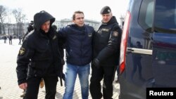 Полицейские уводят задержанного мужчину. Минск, 26 марта 2017 года.