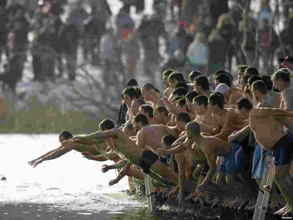 Men jump into the icy waters of a lake in an attempt to grab a wooden cross on Epiphany Day in Sofia on January 6. Photo by Anton Popov for Reuters