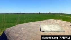 Камень без таблічкі на фоне засеянага поля