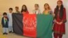 Afghan children holding national flag.