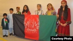 Afghan children holding national flag.