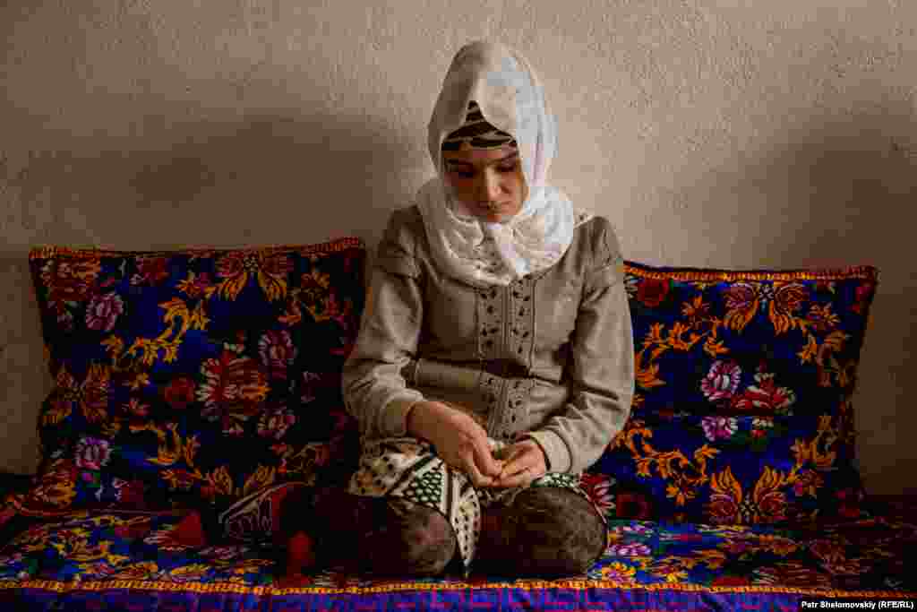 Zarina Yunusova in the living room of her parents' house in the town of Obigarm in Tajikistan.