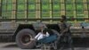 په چمن کې یو ماشوم یو سپینږیری سړی له ولاړو لاریو سره نېږدې لېږدوي - د ۲۰۱۱ز کال د نومبر ۲۸مې انځور. 