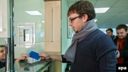 A Moldovan citizen presents his passport at customs at Chisinau International Airport.