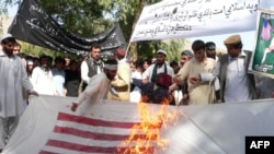 Афганские студенты жгут американский флаг во время акции протеста против фильма "Невинность мусульман". Афганистан, 19 сентября 2012 года.