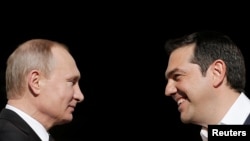 Greek Prime Minister Alexis Tsipras (right) welcomes Russian President Vladimir Putin in Athens on May 27.